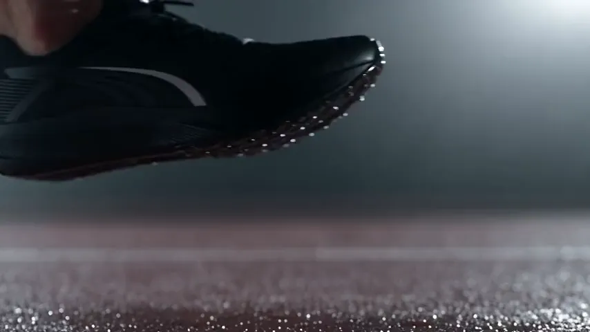 ランニングシューズのプロンプトをSeedance 2.5で生成したテストクリップ：濡れたトラックに向かって降りてくる黒いランニングシューズが、トラックに着地し、水滴を散らしながら蹴り出す。