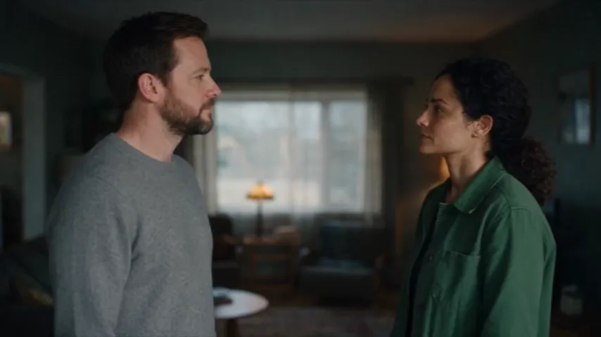 Seedance 2.5 test render of the two-person dialogue prompt: a man in a gray sweater and a woman in a green jacket face each other in a living room, then an over-the-shoulder shot of the woman.