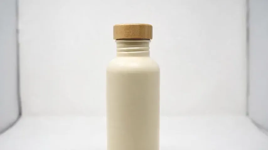 I2V test render: it opens on the white-background product photo, cuts to a sunlit oak counter, and ends with the cap removed beside the bottle.